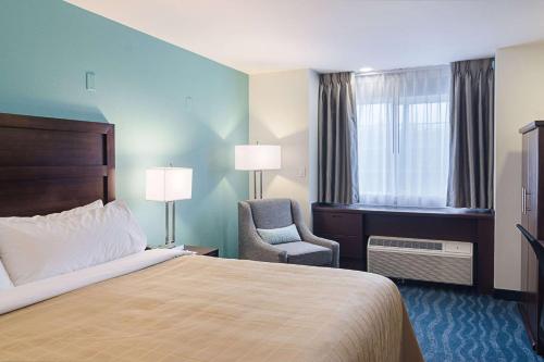 西塞德海滨品质酒店的酒店的客房 - 带一张床、椅子和窗户