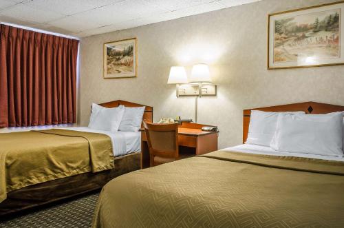 州学院Rodeway Inn State College - near University的酒店客房配有两张床和一张书桌