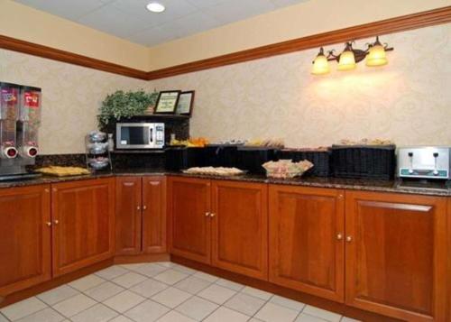 本赛霖姆本萨勒姆品质旅馆&套房酒店的厨房配有木制橱柜和台面