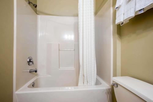 哈里斯堡赫希哈里斯堡汽车旅馆的白色的浴室设有浴缸和卫生间。