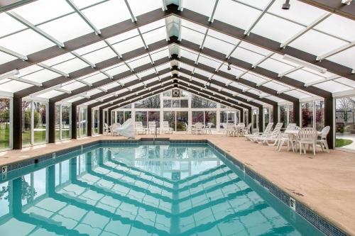 米德尔敦Quality Inn & Suites Middletown - Newport的一个带玻璃天花板和游泳池的室内游泳池