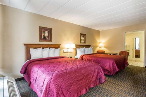 伊斯利伊斯利品质酒店的配有粉红色毯子的酒店客房的两张床