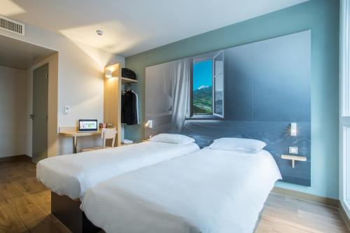 Saint-CerguesB&B HOTEL ANNEMASSE Saint-Cergues的配有窗户的酒店客房内的两张床