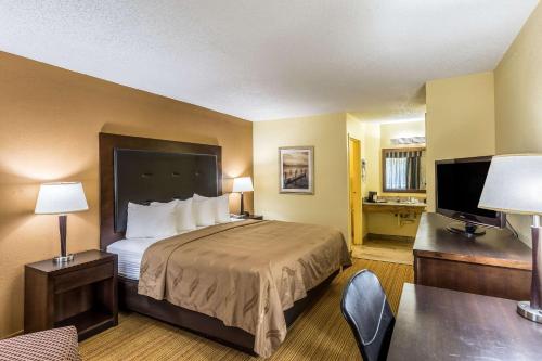 安德森Quality Inn Clemson near University的配有一张床和一张书桌的酒店客房