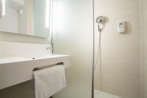 Saint-CerguesB&B HOTEL ANNEMASSE Saint-Cergues的带淋浴、盥洗盆和镜子的浴室