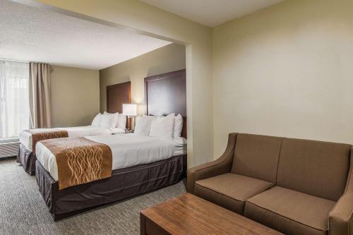 格林伍德Comfort Inn & Suites Greenwood near University的酒店客房,设有两张床和一张沙发