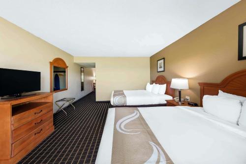 赛维尔维尔Quality Inn & Suites Sevierville - Pigeon Forge的酒店客房设有两张床和一台平面电视。