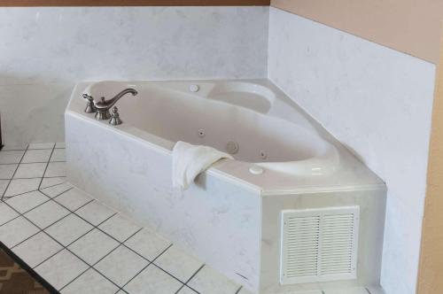 孔洛Comfort Inn North Conroe的浴室设有白色浴缸,配有毛巾