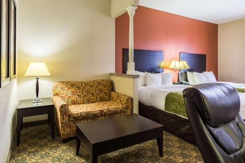 休斯顿Comfort Suites Westchase Houston Energy Corridor的配有一张床和一把椅子的酒店客房