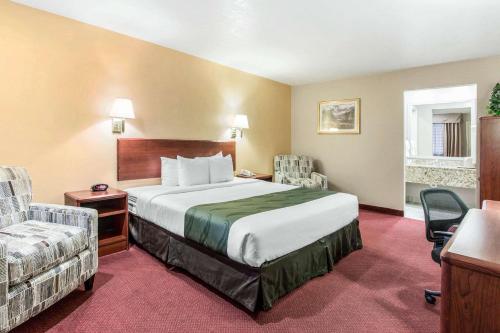 雪松城Quality Inn Cedar City - University Area的配有一张床和一把椅子的酒店客房