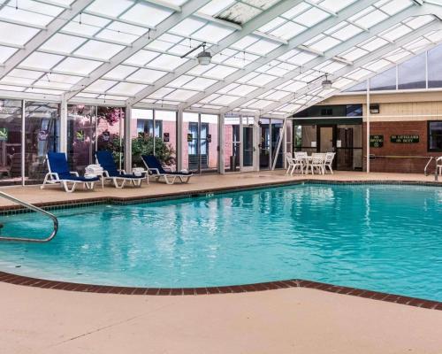 诺福克品质套房酒店赖湖特诺福克机场的大楼内带蓝色椅子的大型游泳池