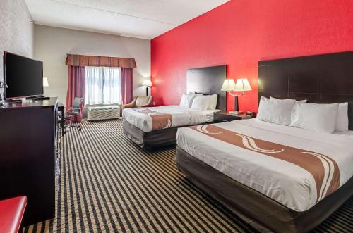 阿宾顿阿宾登品质酒店的酒店客房设有两张床和红色的墙壁。