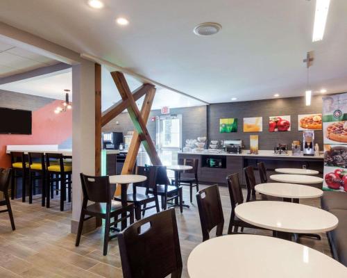 阿什兰Quality Inn & Suites Ashland near Kings Dominion的一间带桌椅的餐厅和一间酒吧