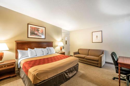 亚基马Holiday Lodge Yakima的酒店客房配有一张床、一张沙发和一张书桌。