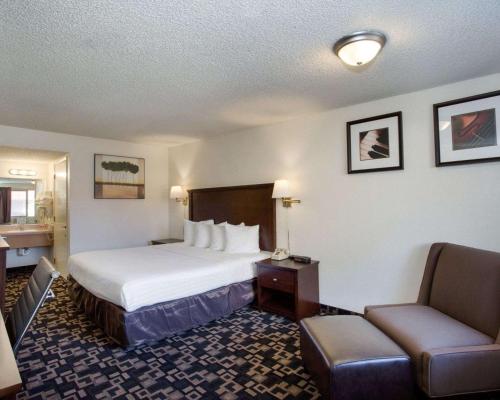 贝灵厄姆MorningGlory Inn & Suites的配有一张床和一把椅子的酒店客房