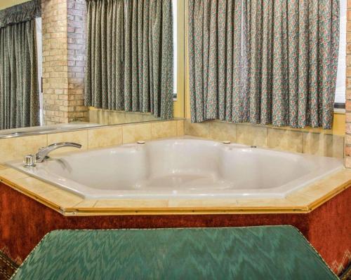 Mosinee威斯康星中部机场品质酒店的配有窗帘的客房内的大浴缸