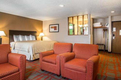 West Bend维斯特本德品质套房酒店的酒店客房,配有一张床和两把椅子