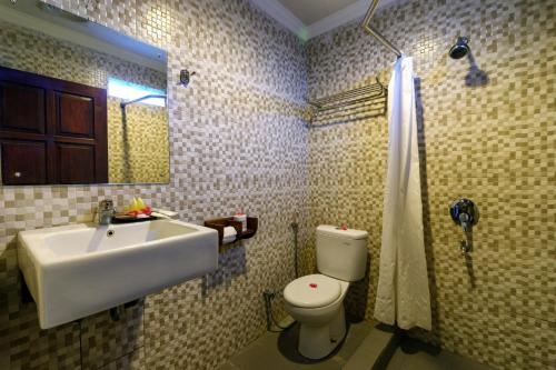 龙目岛库塔Segara Anak Hotel的一间带水槽、卫生间和镜子的浴室