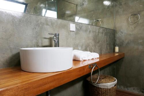 大里贝拉Mitós Vila 3的木制柜台上带白色水槽的浴室