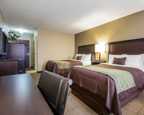 HarlanQuality Inn的酒店客房设有两张床和一张桌子。