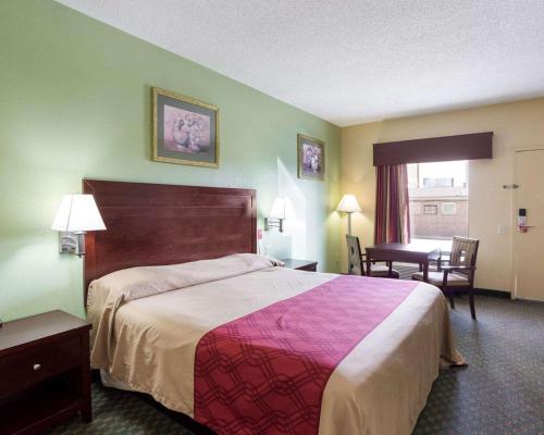 新奥尔良Rodeway Inn & Suites的酒店客房设有一张大床和一张书桌。