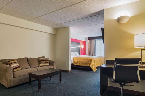福里斯特帕克华美达有限公司套房酒店 - 机场东/森林公园的酒店客房设有一张沙发和一张床