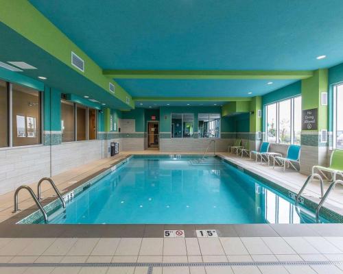 卡尔加里机场北康福特茵套房酒店的酒店的大型游泳池周围设有椅子
