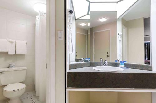 三河城Travelodge by Wyndham Trois-Rivieres的一间带水槽、卫生间和镜子的浴室
