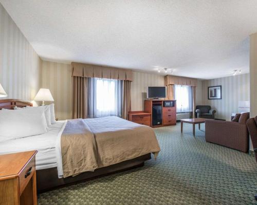 科罗拉多斯普林斯Quality Inn Airport的酒店客房设有床和客厅。