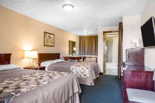 布兰福德Rodeway Inn & Suites Branford - Guilford的酒店客房设有两张床和电视。