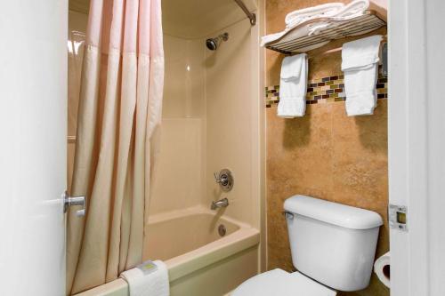 基西米Quality Inn Clermont West Kissimmee的带淋浴、卫生间和浴缸的浴室