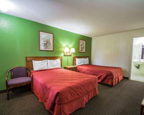 皮尔斯堡Rodeway Inn Fort Pierce I-95的酒店客房,配有两张床和椅子