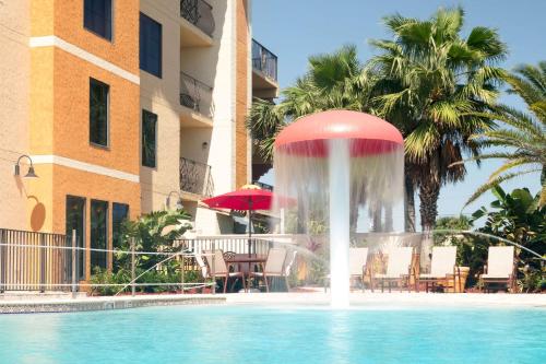 圣奥古斯丁海滩Castillo Real Resort Hotel的一座游泳池中的喷泉,位于大楼旁边