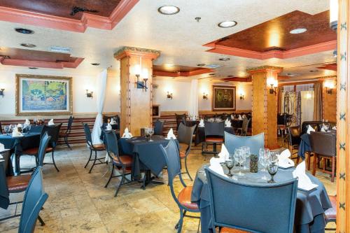 圣奥古斯丁海滩Castillo Real Resort Hotel的一间配备有蓝色桌椅的用餐室