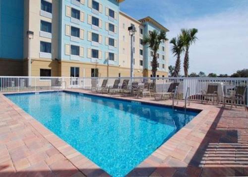 棕榈湾棕榈湾康福特套房酒店 - 墨尔本的大楼前的大型游泳池