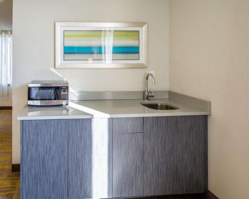 迈阿密迈阿密机场北舒适套房酒店的厨房配有水槽和台面上的微波炉