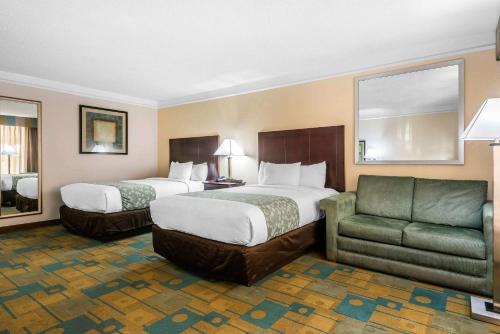 奥兰多SonoHotel IDrive Orlando的酒店客房,设有两张床和一张沙发