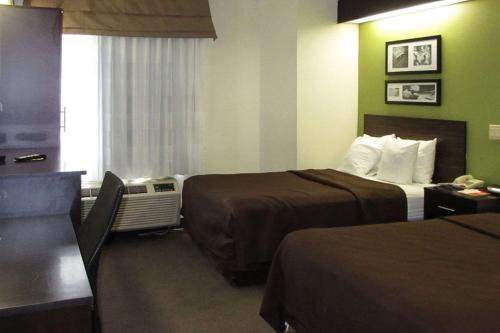 奥尔巴尼Rodeway Inn的酒店客房设有两张床和窗户。