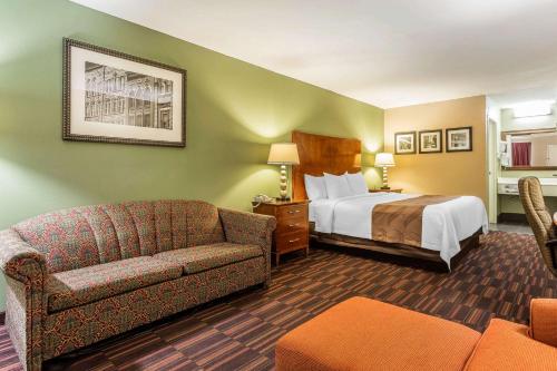 华纳罗宾斯Quality Inn & Suites near Robins Air Force Base的酒店客房,配有床和沙发