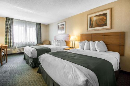 迪比克Quality Inn Dubuque on Hwy 20的酒店客房设有两张床和窗户。