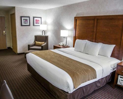 Le ClaireComfort Inn & Suites Riverview near Davenport and I-80的酒店客房带一张大床和一把椅子