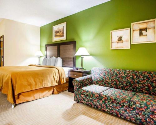 尚佩恩品质套房香槟酒店的酒店客房,配有床和沙发