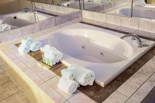 席勒公园奥黑尔机场品质酒店的浴室内带毛巾的大浴缸