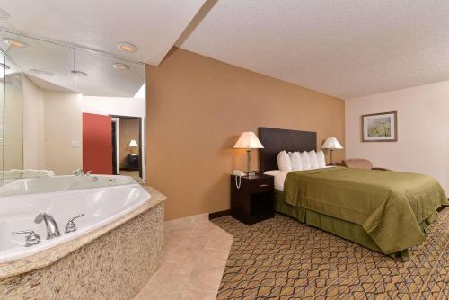 马特森Quality Inn & Suites Matteson near I-57的酒店客房配有一张床和浴缸。