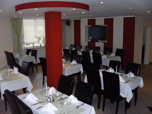 奥格斯堡阿德勒酒店 的用餐室配有白色桌子和黑色椅子
