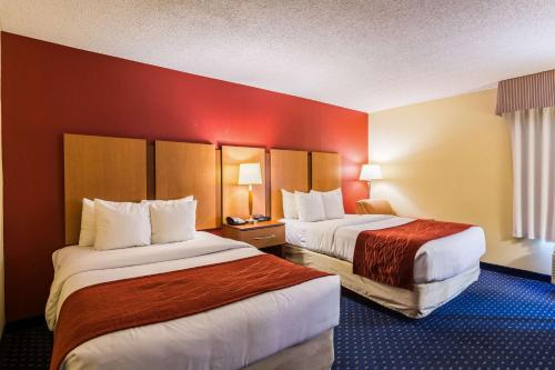 克林顿华盛顿特区安德鲁斯空军基地康福特茵酒店的酒店客房,设有两张带红色墙壁的床