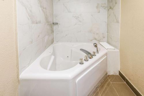 底特律Comfort Inn Downtown Detroit的浴室铺有白色瓷砖,配有白色浴缸。