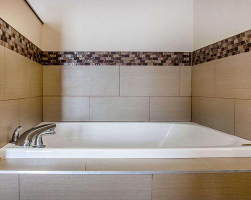本顿港本顿港 - 圣约瑟夫康福特套房酒店的浴室内设有大型白色浴缸。