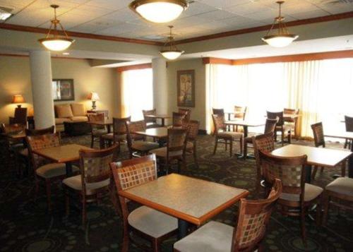 弗洛里森特圣路易斯西北品质酒店 I-270的餐厅设有木桌、椅子和窗户。