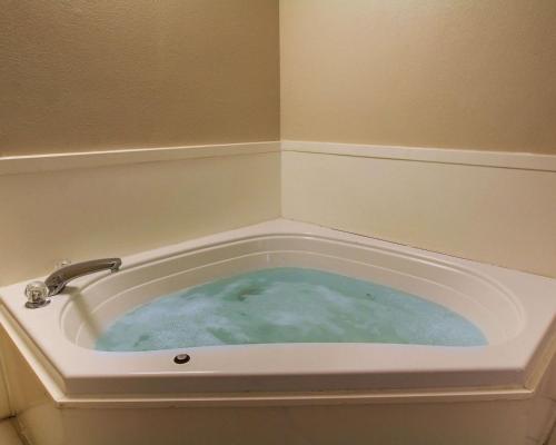 哈蒂斯堡哈蒂斯堡品质套房酒店的装满蓝色水面的浴缸